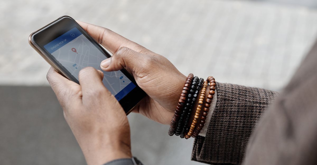 Main tenant un smartphone avec une carte de localisation affichée à l'écran