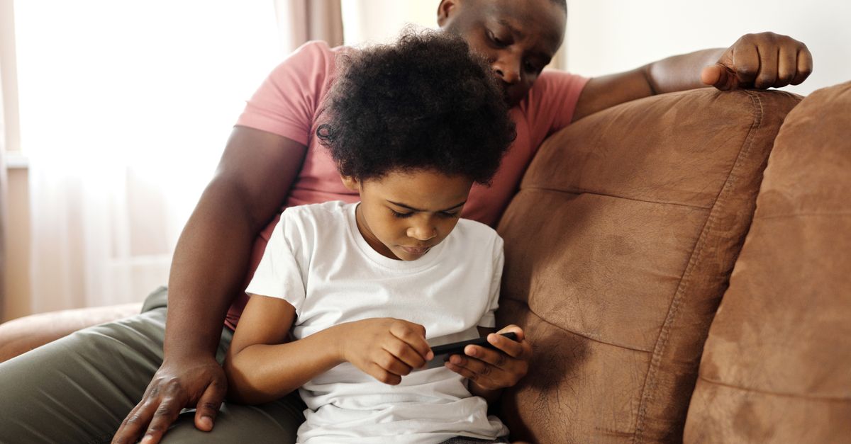 Un parent configure une application de contrôle parental sur le smartphone de son enfant